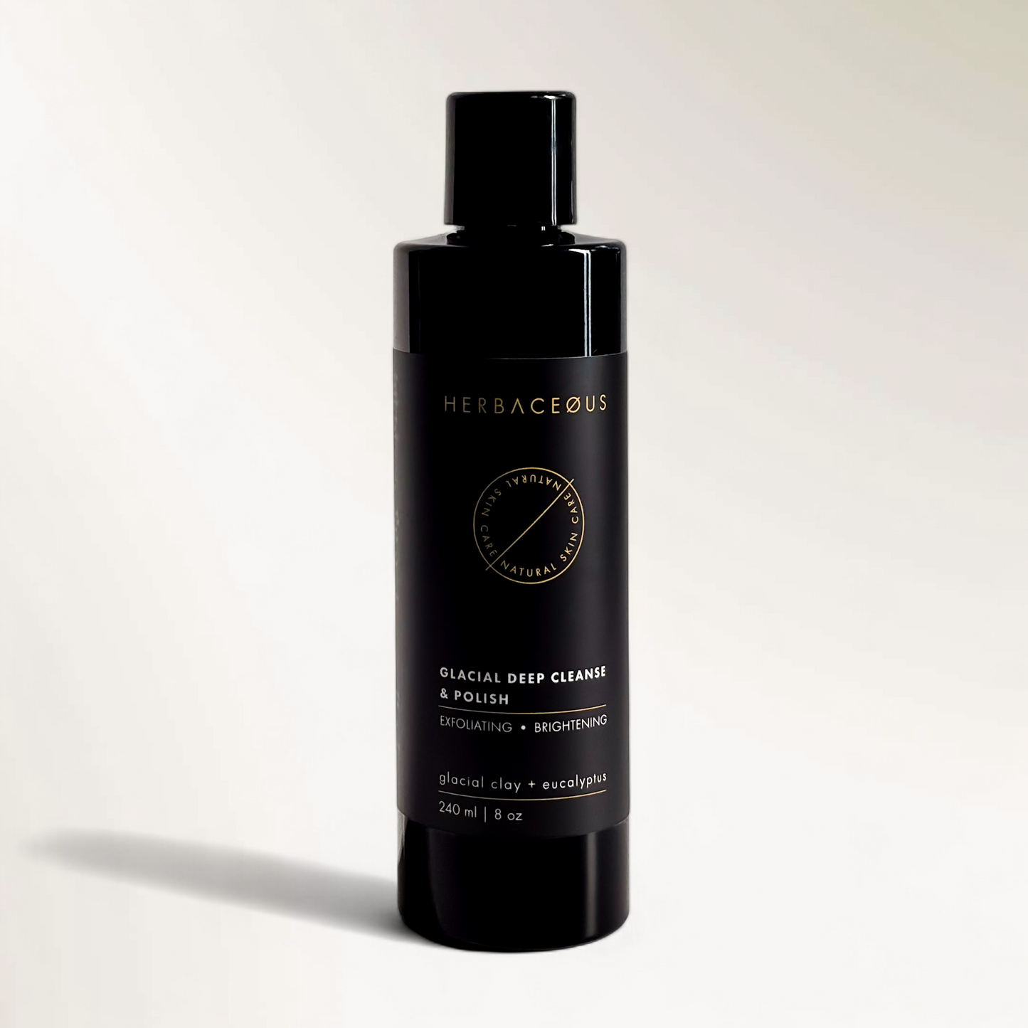 Black bottle of Herbaceous glacial deep cleanse and polish on a light gray background