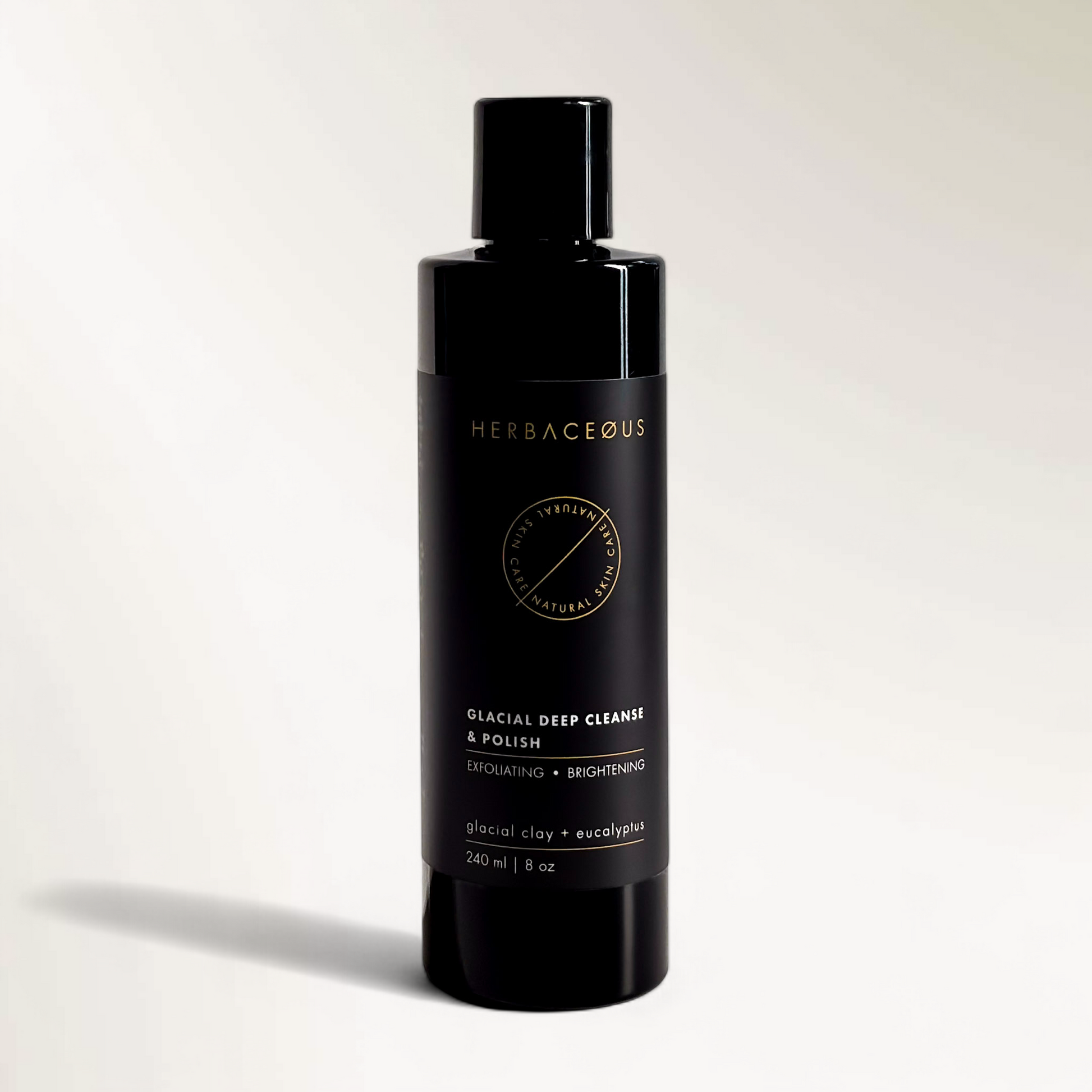 Black bottle of Herbaceous glacial deep cleanse and polish on a light gray background